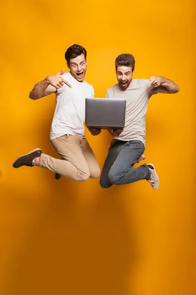 Retrato Comprimento Total Dois Jovens Animados Melhores Amigos Segurando Computador — Fotografia de Stock