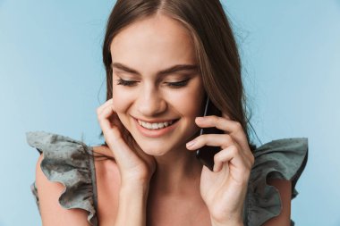 Cep telefonu üzerinde mavi arka plan izole konuşurken içinde güzel bir genç kadın portresi kapatın