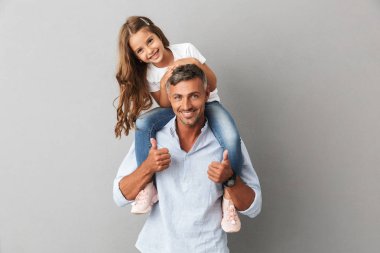 Portre sevimli aile, gülümseyerek ve babası 30'lu boyun üzerinde oturan kızı gri arka plan üzerinde izole