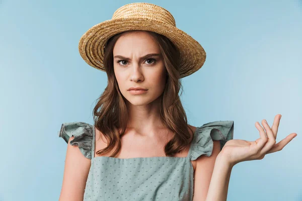 关闭在穿着和夏季帽子的愤怒的女人的肖像看着相机孤立的蓝色背景 — 图库照片