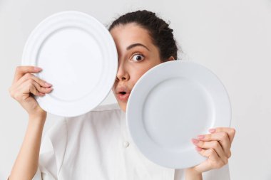 Tek tip gösteren iki tabak beyaz arka plan üzerinde izole bir oynak genç kadın aşçı portresi giymiş