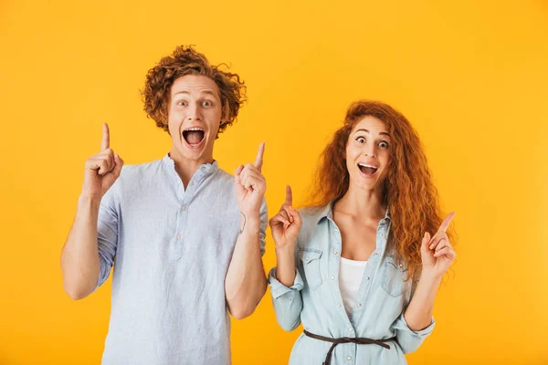 Imagem Amigos Excitados Casal Amoroso Isolado Sobre Fundo Amarelo Apontando — Fotografia de Stock