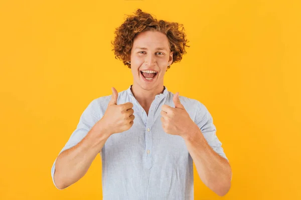 笑みを浮かべて 黄色背景に分離カメラで親指を現しては 代男はハンサムな興奮の肖像画 — ストック写真