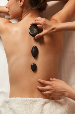 Top view of a woman having hot stone massage in spa clipart