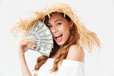Sevindirici ve beyaz arka plan üzerinde izole doları nakit hayranı tutan mutlu zengin kadın 20'li yaşlarda giyen büyük hasır şapka fotoğrafı