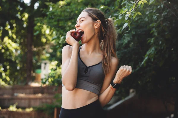 Portrait Excited Young Fitness Girl Biting Apple Outdoors — Stock Photo, Image