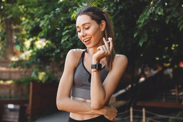 Portrait Cheerful Young Fitness Girl Holding Wireless Earphones Outdoors — Stock Photo, Image