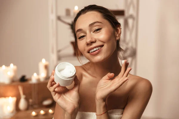 Retrato Una Hermosa Joven Envuelta Una Toalla Aplicando Crema Corporal —  Fotos de Stock