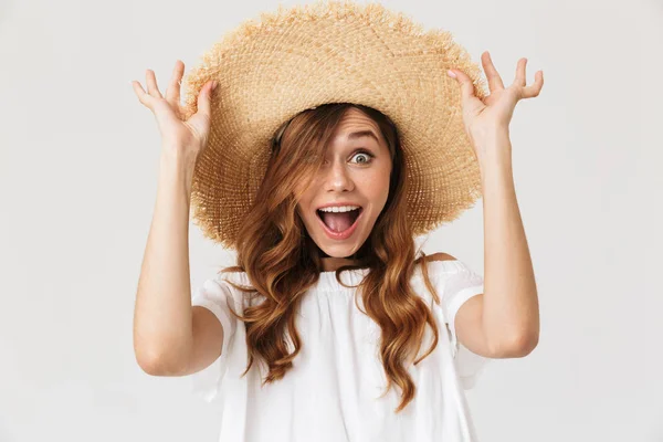 面白いヨーロッパ女性 代笑顔と大きな麦藁帽子に触れる白い背景に分離された彼女の頭の上の肖像画 — ストック写真