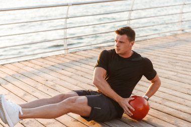 Yakışıklı genç sporcu ile deniz kenarında bir ağır top yapıyor