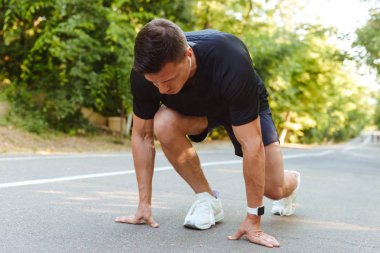 Kulaklıklar açık havada çalıştırmak hazırlanıyor genç sporcu odaklı