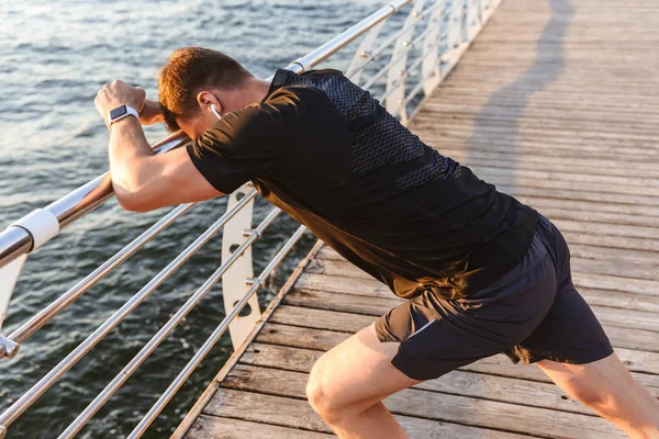 Egészséges Fiatal Sportoló Csinál Stretching Gyakorlatok Közben Támaszkodva Sínek Tengerparton — Stock Fotó