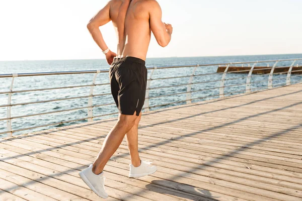 Deniz kıyısı çalışan sporcu görüntü arkadan görünüm kırpılmış