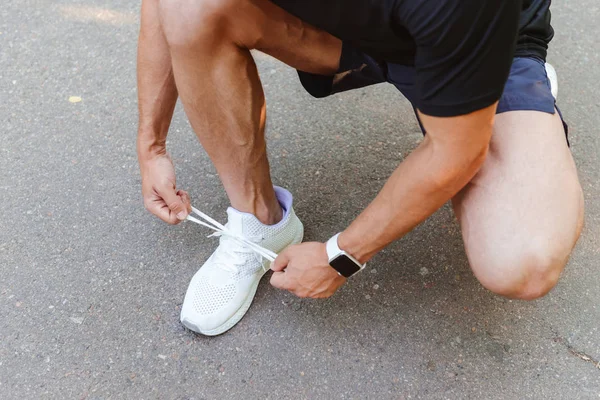 Close Jovem Desportista Fones Ouvido Amarrando Seu Atacador Antes Correr — Fotografia de Stock