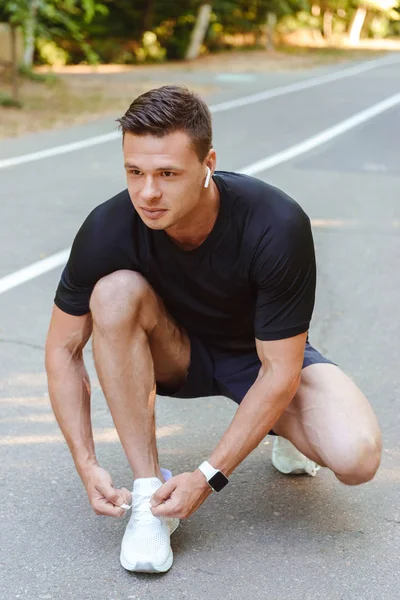 Jovem Desportista Focado Fones Ouvido Amarrando Seu Atacador Antes Correr — Fotografia de Stock