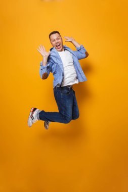 Görüntü izole sarı arka plan üzerinde duygusal şok adamın atlama.