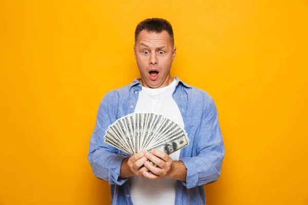 Imagem Homem Bonito Chocado Isolado Sobre Fundo Amarelo Segurando Dinheiro — Fotografia de Stock