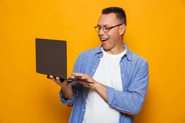 Dizüstü Bilgisayar Kullanan Sarı Arka Plan Üzerinde Izole Mutlu Duygusal — Stok fotoğraf
