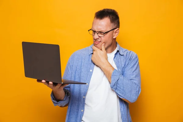 Imagem Homem Confuso Isolado Sobre Fundo Amarelo Usando Computador Portátil — Fotografia de Stock