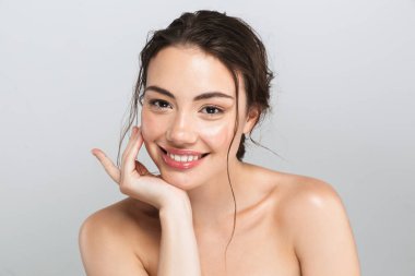 Beauty portrait of a happy young topless woman with make up looking at camera isolated over gray background clipart