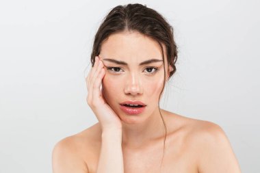 Gri arka plan üzerinde izole kamera bakarak makyaj ile genç ve güzel bir üstsüz kadın güzellik portresi