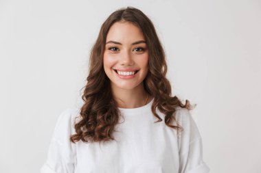 Beyaz arka plan üzerinde izole kamera bakarak bir gülümseyen genç casual esmer kadın portresi