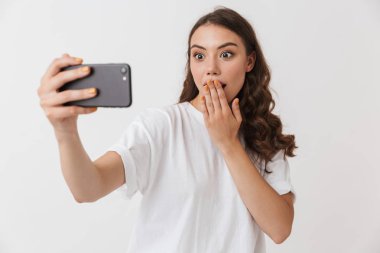 Beyaz arka plan üzerinde izole selfie alarak genç ve güzel bir casual esmer kadın portresi