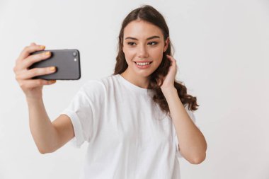 Beyaz arka plan üzerinde izole selfie alarak bir gülümseyen genç casual esmer kadın portresi