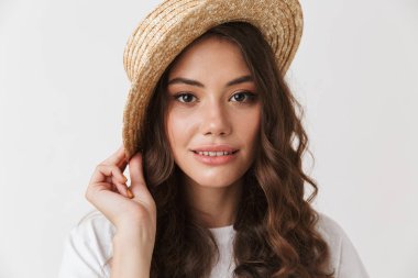 Çekici bir genç casual esmer kadın beyaz arka plan üzerinde izole kamera bakarak poz şapkalı portresi kapatın