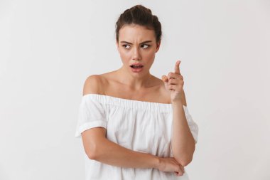 Beyaz arka plan üzerinde izole kamera gösteren bir hayal kırıklığına genç casual esmer kadın portresi