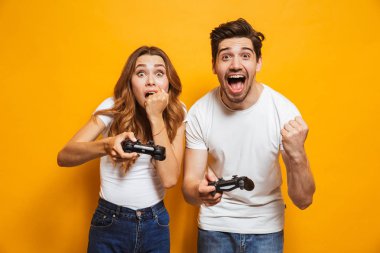 Mutlu bir adam ve birlikte izole sarı arka plan üzerinde joystick ile video oyunları oynarken hayal kırıklığına kadın görüntüsü