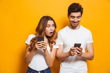 Casusluk ve smartphone sevgilisi sarı arka plan üzerinde izole gözatma genç kadın görüntüsünü
