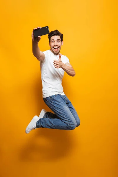 Full Length Portrait Joyful Young Man Taking Sefie Mobile Phone — Stock Photo, Image