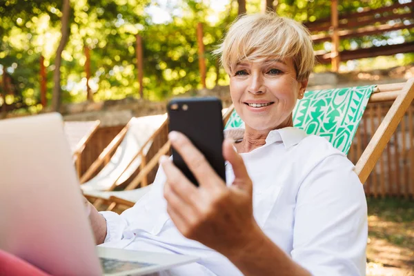 Lachende Volwassen Vrouw Houden Van Mobiele Telefoon Terwijl Rust Het — Stockfoto