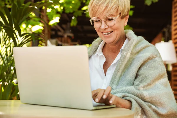 Счастливая Зрелая Женщина Завернутая Одеяло Сидит Кафе Ноутбуком — стоковое фото
