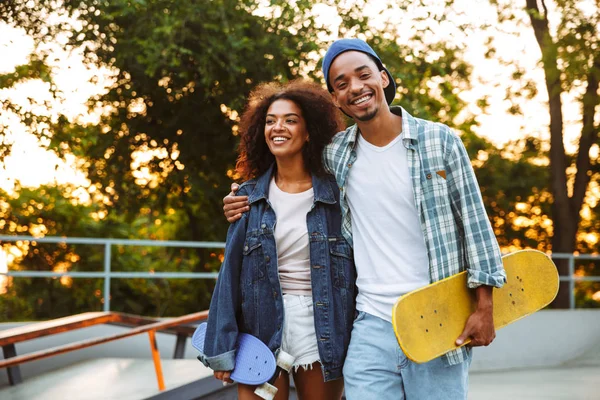 Portret Van Een Gelukkige Jonge Afrikaanse Paar Met Skateboards Staan — Stockfoto