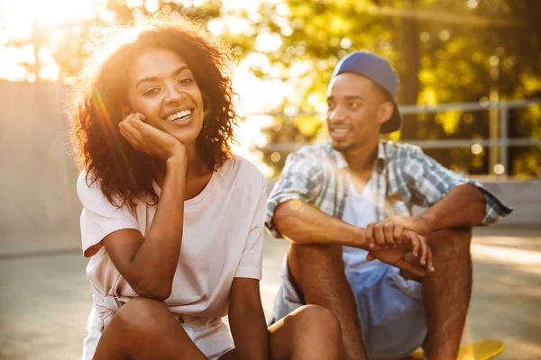 Portret Van Een Lachende Jonge Afrikaanse Paar Met Skateboard Zitten — Stockfoto