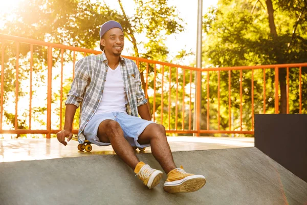 Szczęśliwy Młody Człowiek Afryki Deskorolka Siedzi Ziemi Skate Parku — Zdjęcie stockowe