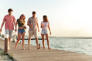 Grup dört arkadaşıyla sahilde açık havada resim.