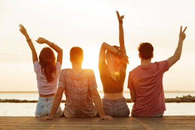 Grup açık havada barış hareketi gösterilen sahilde yürüyüş çiftler sevgi dolu dört arkadaşıyla fotoğrafı görünümü geri.