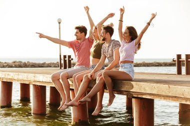 Açık havada oturma plaj işaret eden grup sevgi dolu dört arkadaşıyla resmini çiftler.