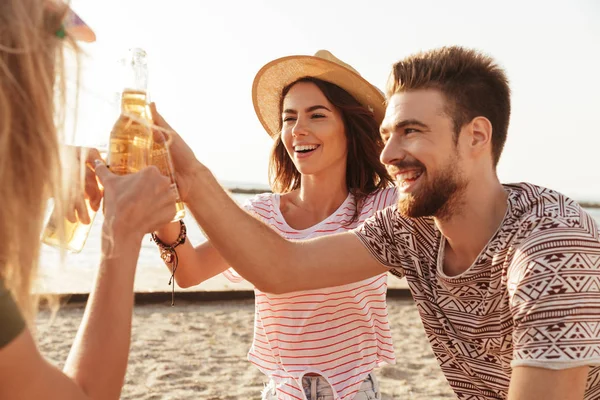 一群快乐的朋友穿着夏装 在海滩上用啤酒瓶祝酒 — 图库照片