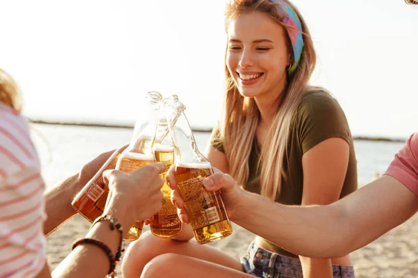ビーチでビールボトルで乾杯する夏の服を着た陽気な友人のグループ — ストック写真