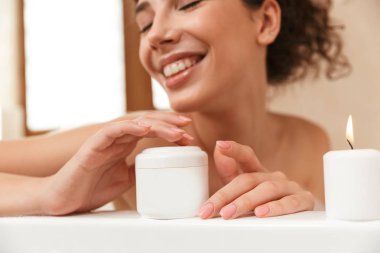 Banyoda genç güzel kadın görüntüsünü krem kamera için gösterilen banyo dinlenme yatıyor.