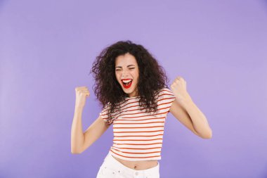 Çığlık ve Studio violet arka plan üzerinde izole yumruk kenetlenmesi yaz aşınmaya kıvırcık saçlı heyecanlı neşeli kadın fotoğrafı