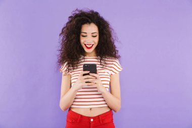 İzole, cep telefonuyla duran genç ve güzel bir casual kadın portresi