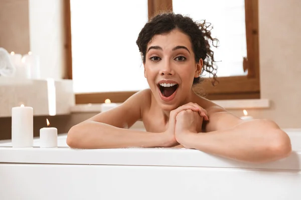 年轻的情感兴奋的形象在浴室里躺在浴缸里的美丽女人 — 图库照片