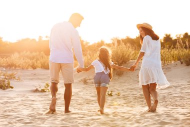Kumsalda birlikte eğleniyor genç mutlu bir aile görünümü resmi geri.