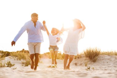 Genç Sevimli aile birlikte açık havada plajda eğlenmek görüntüsünü.