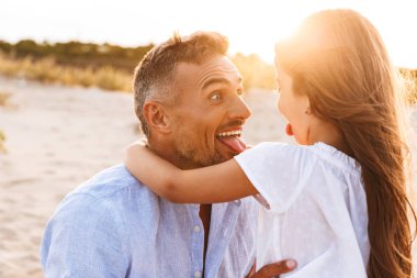 Genç Sevimli aile birlikte açık havada plajda eğlenmek görüntüsünü.
